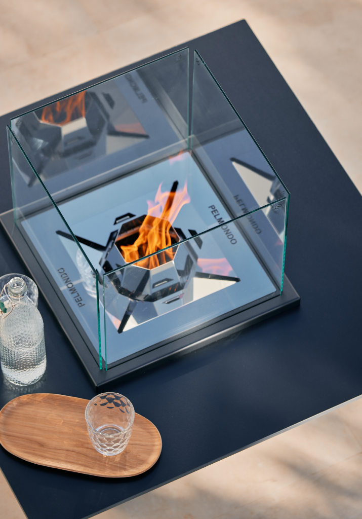 Pelmondo Feuerstelle Cube brennt mit Dekoration auf Tischplatte